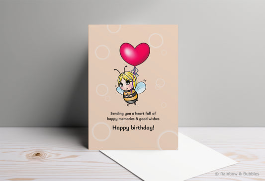 A kawaii birthday card from Rainbow & Bubbles, showing a bee holding a heart balloon.