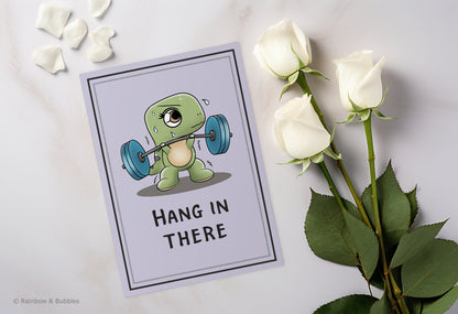 A kawaii greeting card from Rainbow & Bubbles, showing a t-rex struggling to lift weights with his tiny arms.