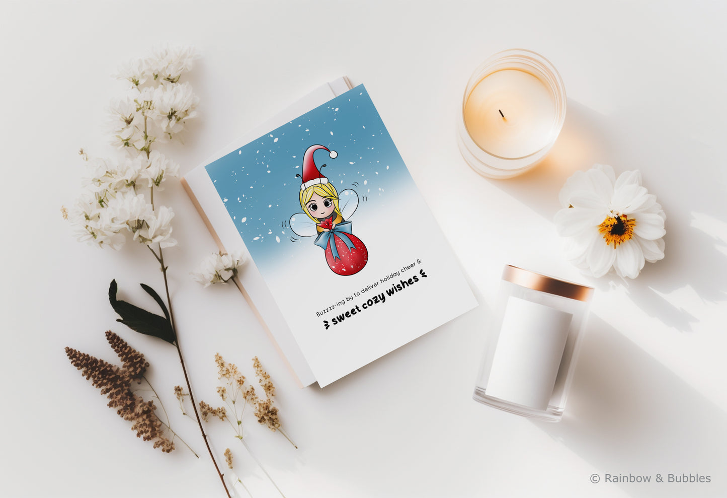 A kawaii greeting card from Rainbow & Bubbles, showing a bee with a santa hat delivering a big pretty bag of gifts.