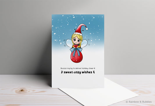 A kawaii greeting card from Rainbow & Bubbles, showing a bee with a santa hat delivering a big pretty bag of gifts.