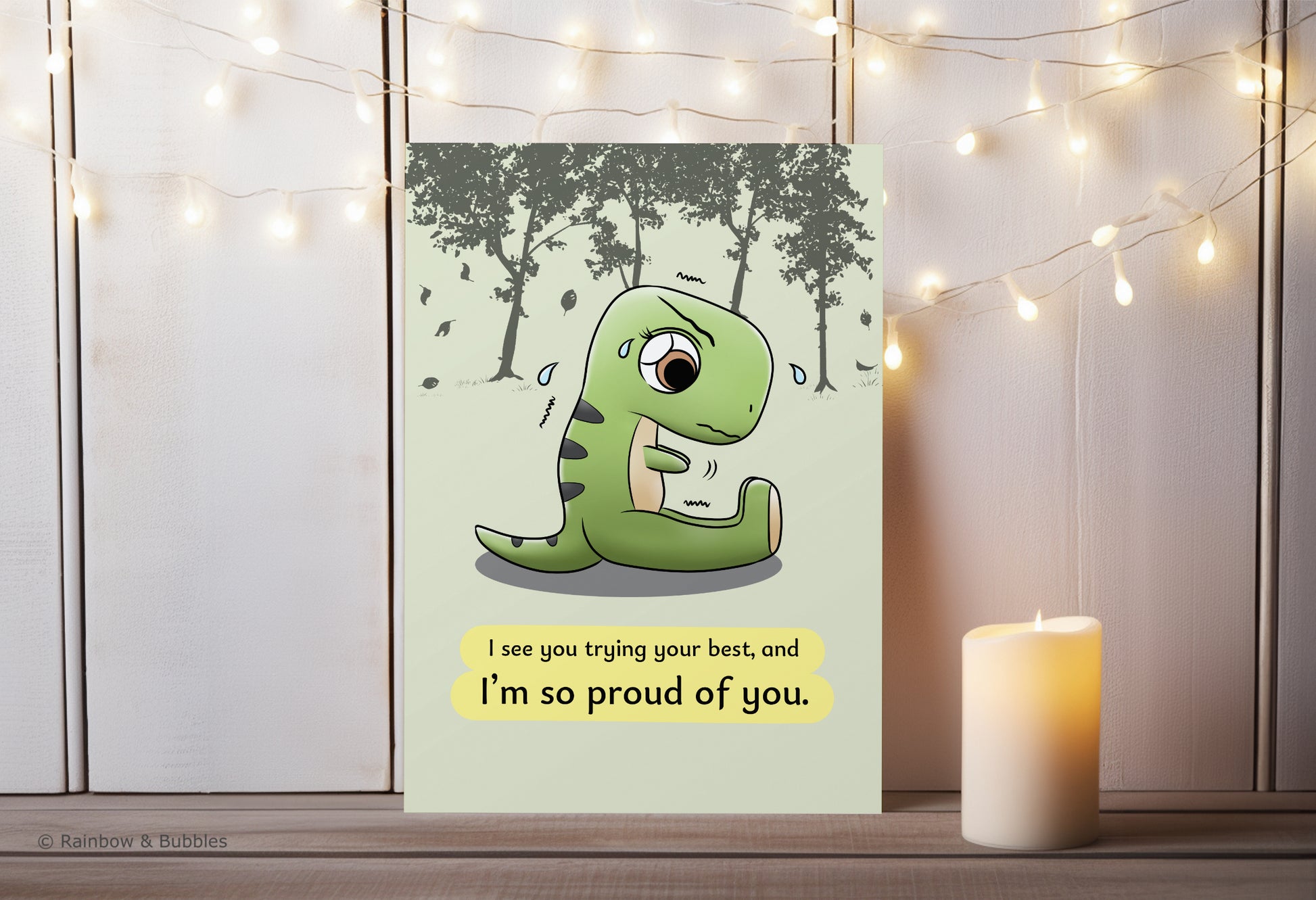 A kawaii greeting card from Rainbow & Bubbles, showing a t-rex stretching and struggling to touch his toes with his little arms.